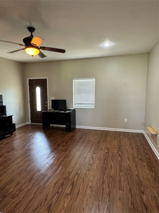 unfurnished living room featuring dark hardwood / wood-style flooring and ceiling fan