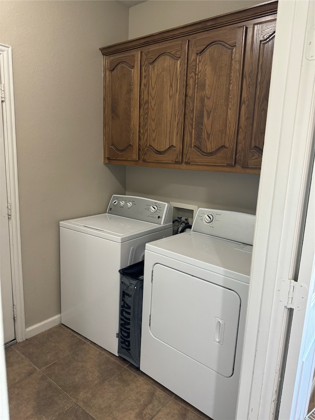 laundry area featuring dark tile patterned flooring, cabinets, and separate washer and dryer