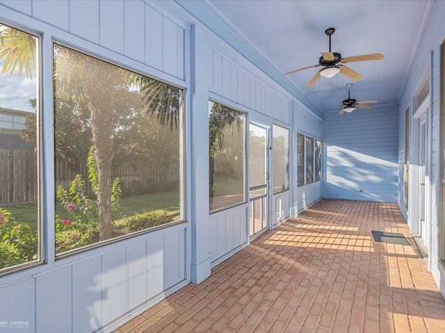 unfurnished sunroom with ceiling fan