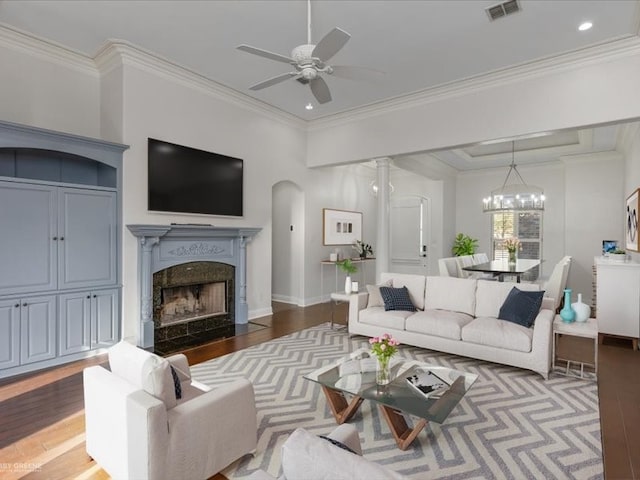 living room with ceiling fan with notable chandelier, crown molding, and hardwood / wood-style floors