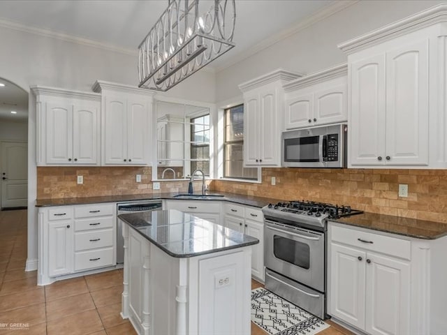 kitchen featuring a center island, stainless steel appliances, sink, pendant lighting, and white cabinetry