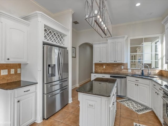 kitchen with stainless steel appliances, sink, white cabinetry, and a center island