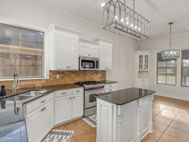 kitchen with pendant lighting, appliances with stainless steel finishes, sink, and white cabinetry