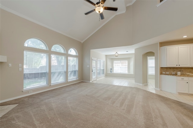 unfurnished living room featuring crown molding, light colored carpet, and high vaulted ceiling