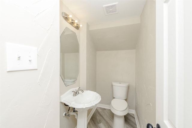 bathroom featuring hardwood / wood-style flooring and toilet