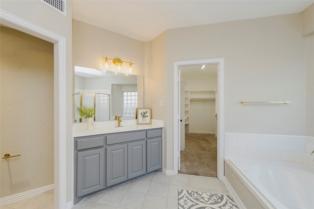 bathroom featuring tile patterned flooring, shower with separate bathtub, and vanity