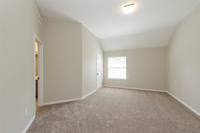 carpeted spare room with lofted ceiling