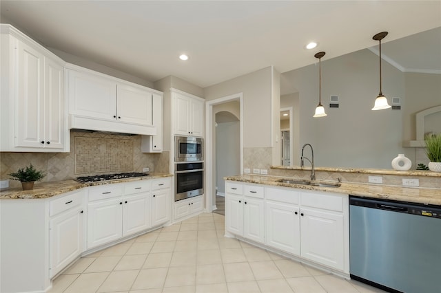 kitchen with stainless steel appliances, white cabinets, tasteful backsplash, and sink