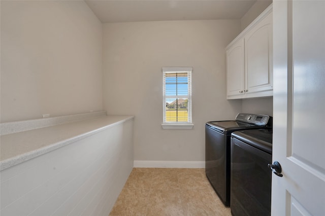 clothes washing area with light tile patterned flooring, washer and dryer, and cabinets