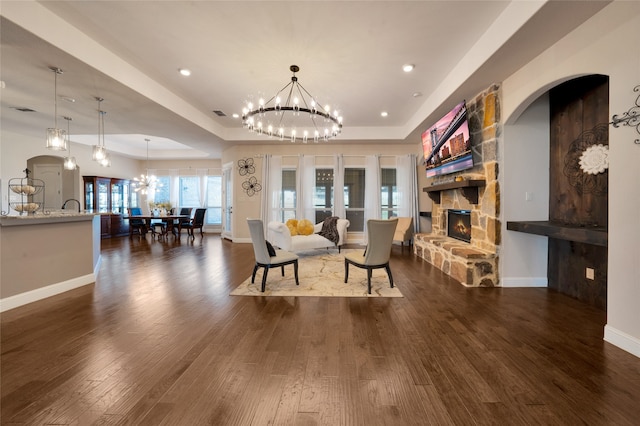 interior space featuring a fireplace, dark wood-type flooring, and a tray ceiling