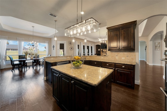 kitchen with a kitchen island, dark brown cabinets, and pendant lighting