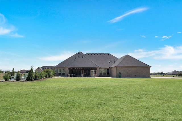 rear view of property featuring a lawn and a patio