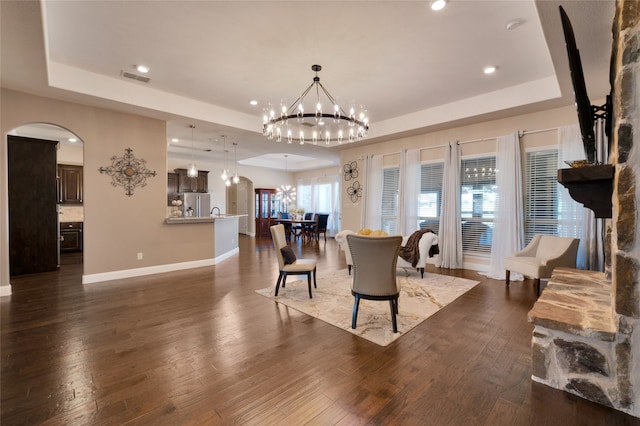 dining space with a tray ceiling and dark hardwood / wood-style flooring