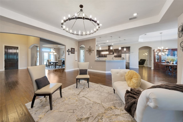 living room with a tray ceiling and hardwood / wood-style flooring