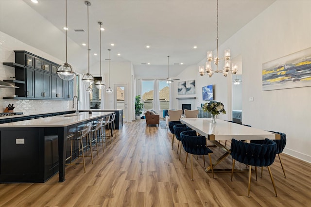 dining room with light wood finished floors, visible vents, ceiling fan, recessed lighting, and a fireplace