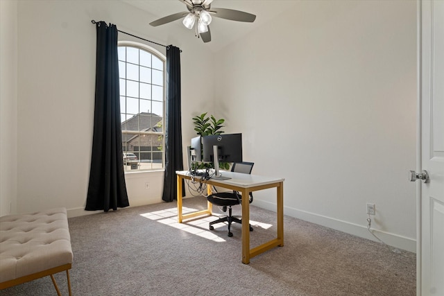 home office featuring lofted ceiling, baseboards, a ceiling fan, and light colored carpet