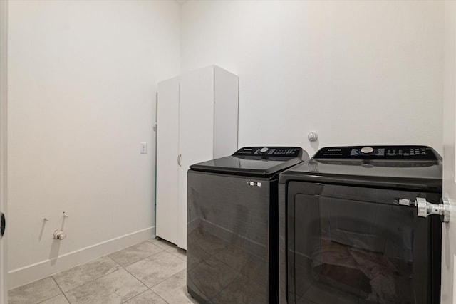 washroom with light tile patterned flooring, independent washer and dryer, and baseboards