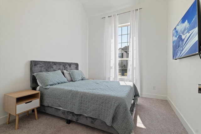 carpeted bedroom with lofted ceiling and baseboards