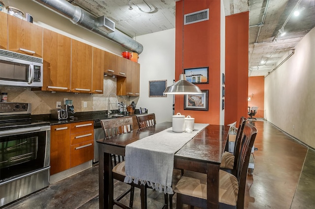 kitchen with appliances with stainless steel finishes, sink, and backsplash