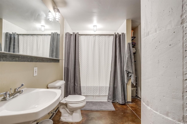 bathroom featuring concrete flooring, sink, toilet, and a shower with shower curtain