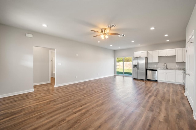 unfurnished living room featuring ceiling fan, dark wood-type flooring, and sink