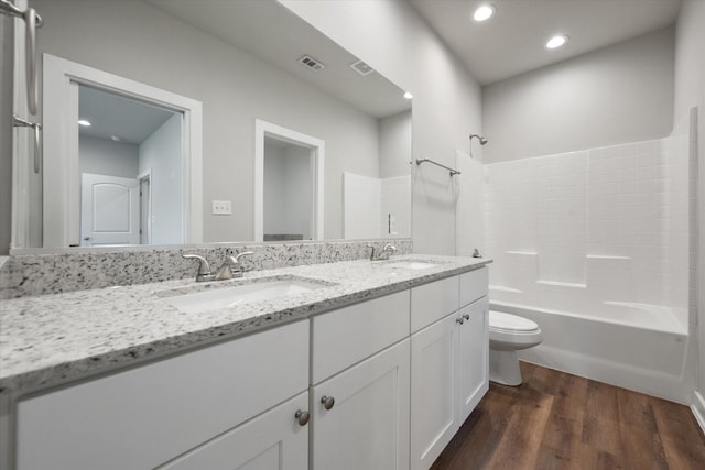 full bathroom with shower / bathing tub combination, vanity, wood-type flooring, and toilet