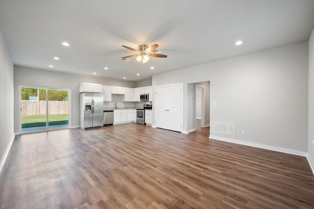 unfurnished living room featuring hardwood / wood-style floors, ceiling fan, and sink