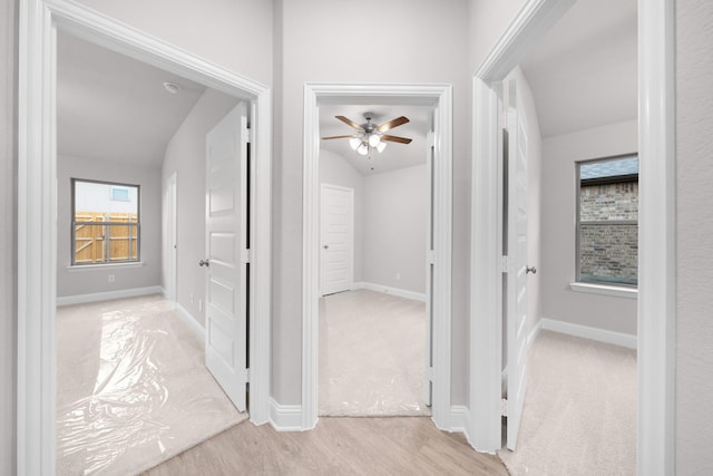 corridor with baseboards and wood finished floors