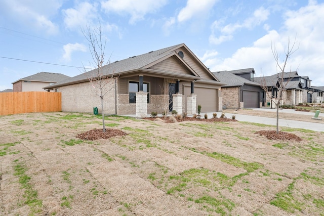 view of front facade featuring fence, a garage, brick siding, and driveway