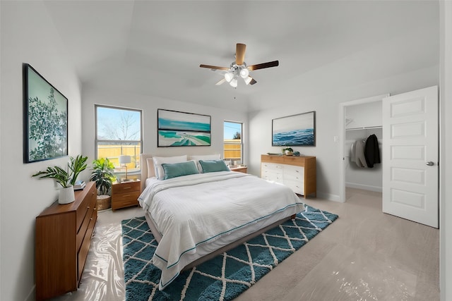 bedroom with a ceiling fan, multiple windows, a closet, and a walk in closet