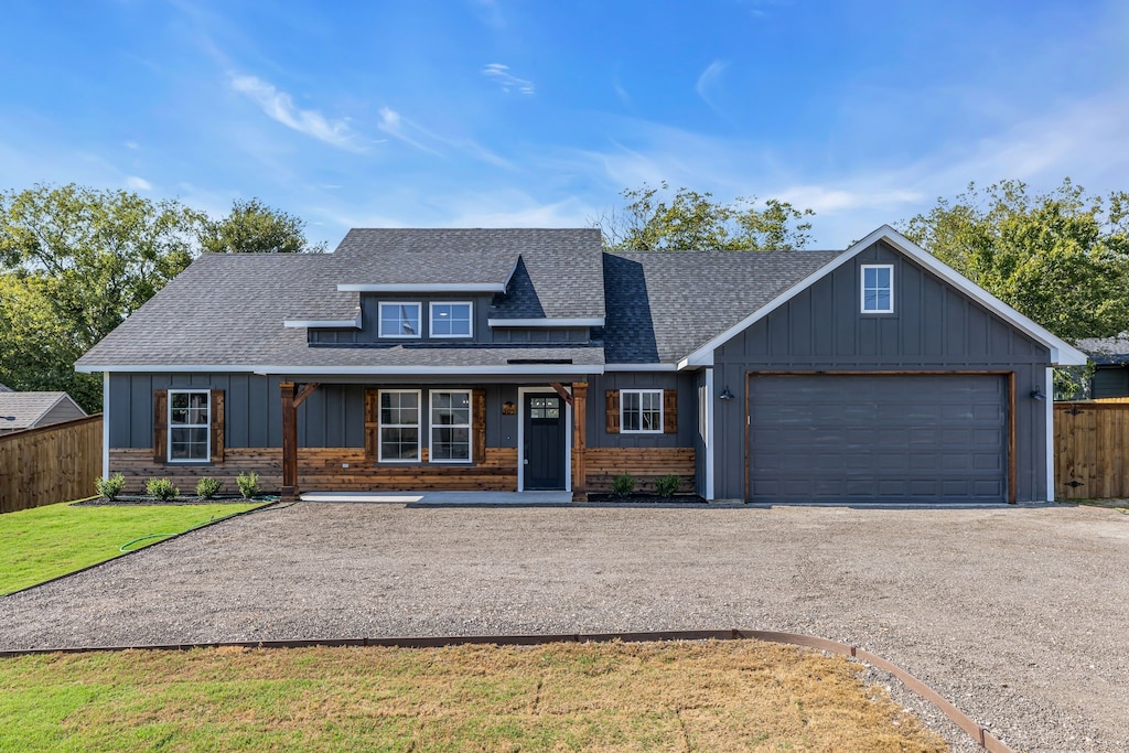 view of front facade with a front lawn, covered porch, and a garage