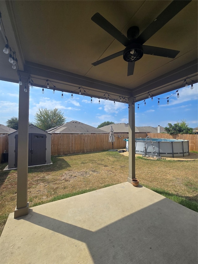 view of patio with ceiling fan, a shed, and a covered pool