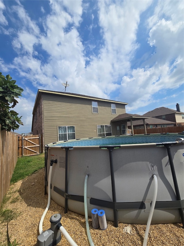 back of property with a fenced in pool