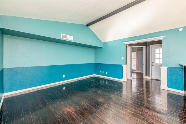 spare room with lofted ceiling with beams and dark wood-type flooring