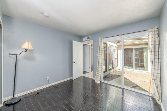 unfurnished room with dark wood-type flooring