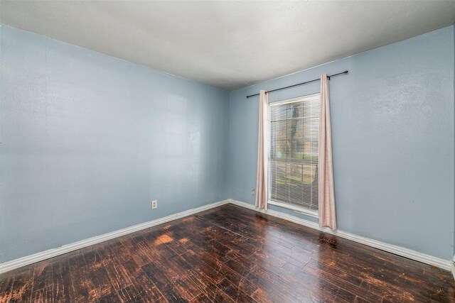 unfurnished room with dark hardwood / wood-style floors