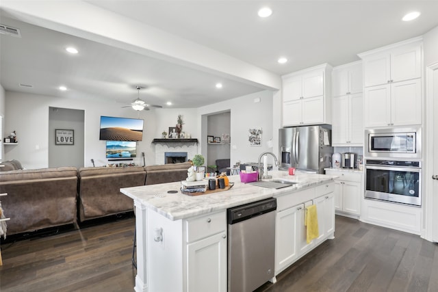 kitchen featuring a center island with sink, white cabinets, appliances with stainless steel finishes, and dark hardwood / wood-style flooring