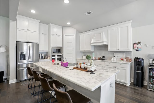 kitchen featuring appliances with stainless steel finishes, tasteful backsplash, dark wood-type flooring, and white cabinets