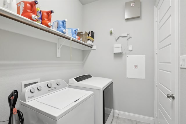 washroom with washing machine and clothes dryer and light tile patterned floors