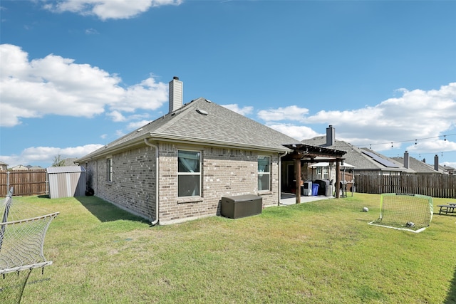 rear view of property with a shed, a patio, and a lawn