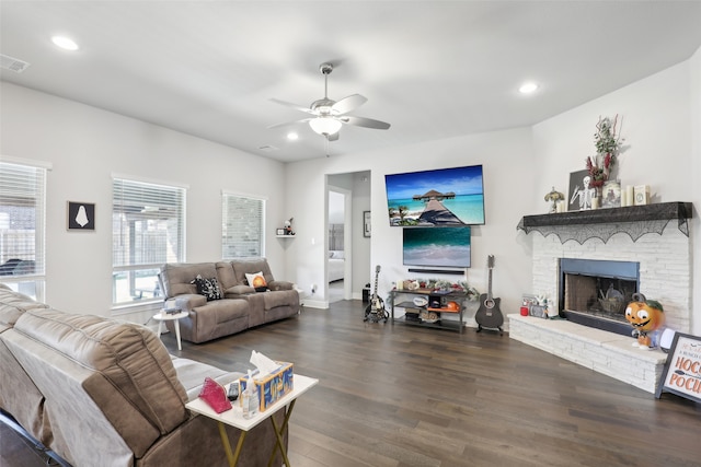 living room featuring ceiling fan, a fireplace, and dark wood-type flooring