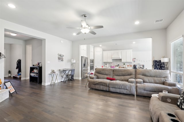 living room with dark hardwood / wood-style flooring and ceiling fan