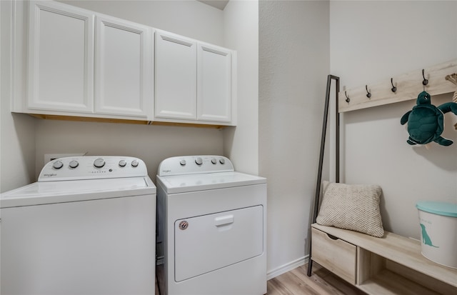 laundry area with light wood-type flooring, separate washer and dryer, and cabinets