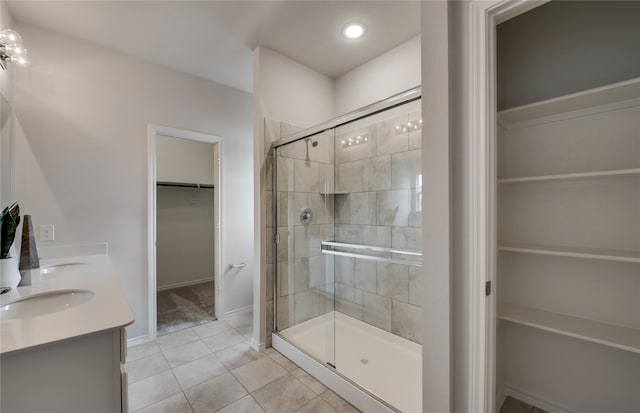 bathroom featuring walk in shower, vanity, and tile patterned flooring