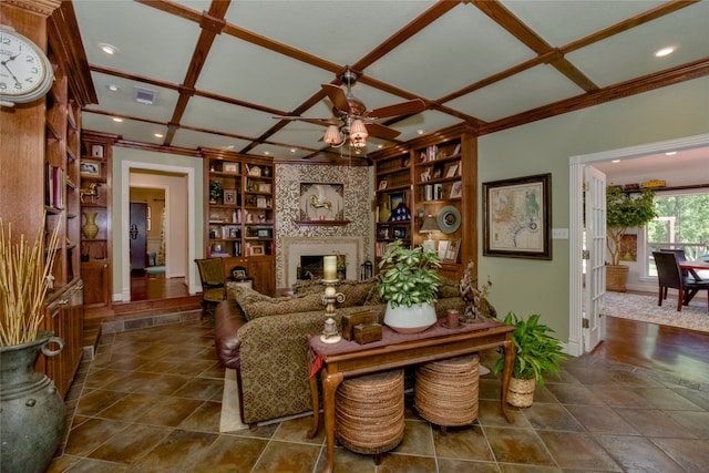 living room with built in shelves, a fireplace, coffered ceiling, and ceiling fan