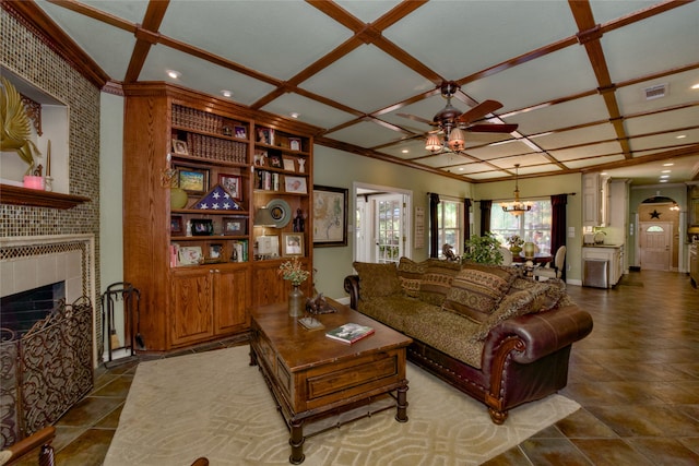 living room with ceiling fan with notable chandelier, coffered ceiling, a large fireplace, sink, and ornamental molding