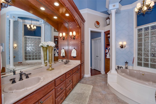 bathroom with tile patterned flooring, an inviting chandelier, a tub, decorative columns, and vanity