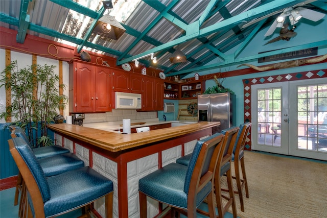 kitchen with french doors, stainless steel fridge with ice dispenser, lofted ceiling with beams, light colored carpet, and butcher block counters