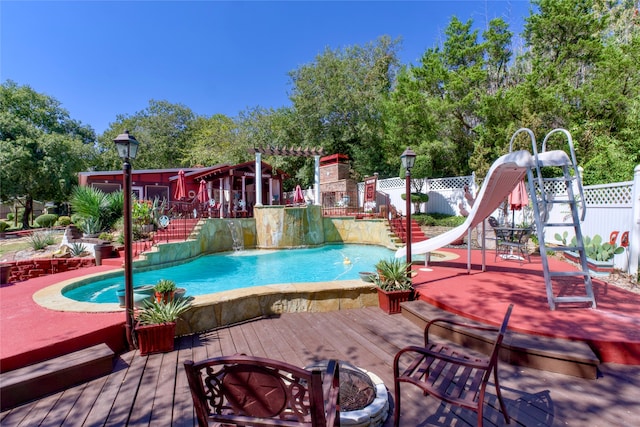 view of swimming pool with a water slide and a deck