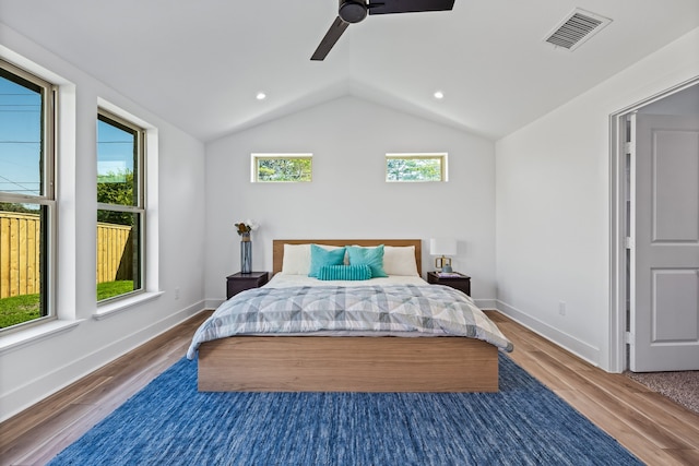 bedroom with ceiling fan, lofted ceiling, and hardwood / wood-style floors